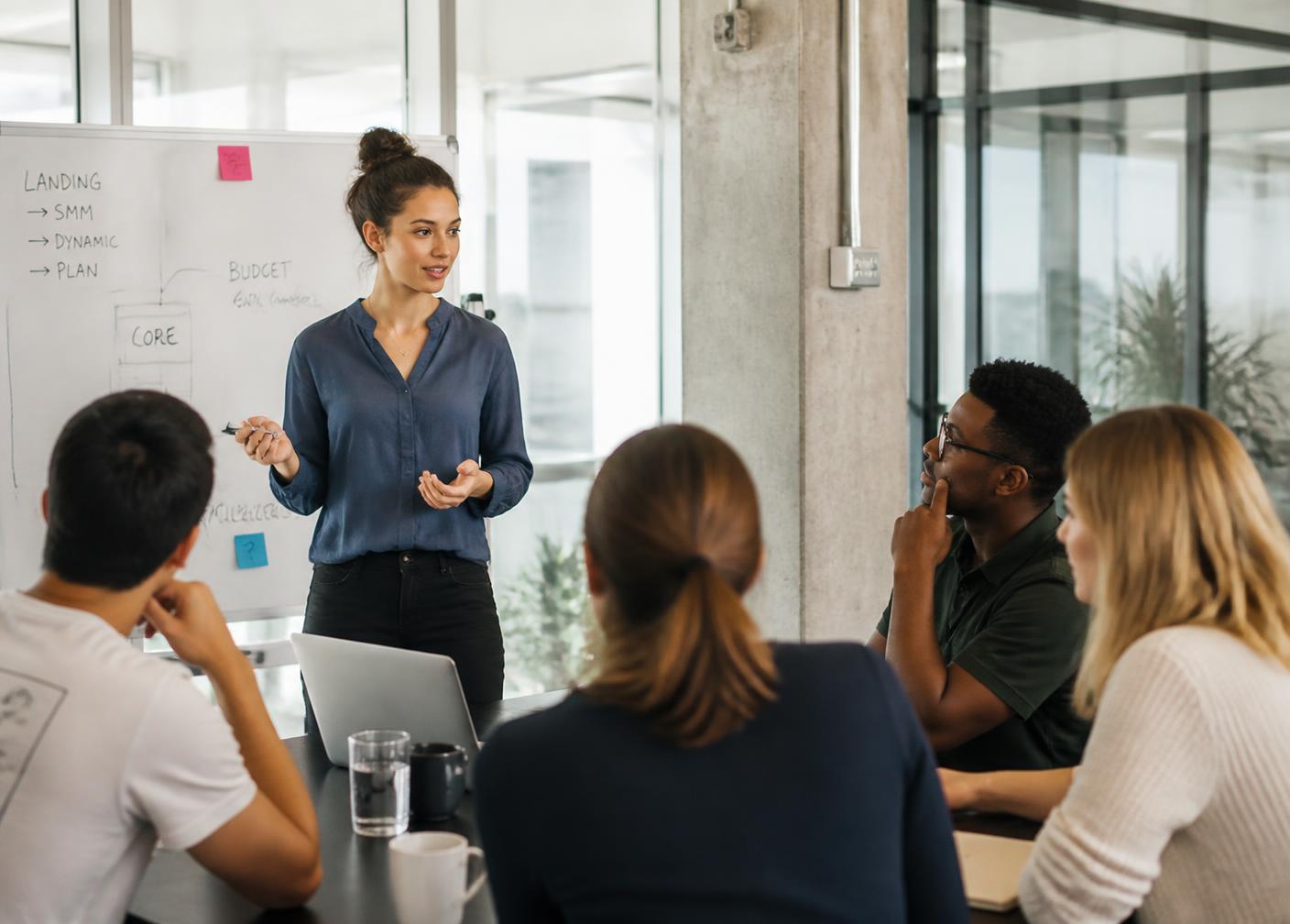 A young professional leading a working session with colleagues in a bright office