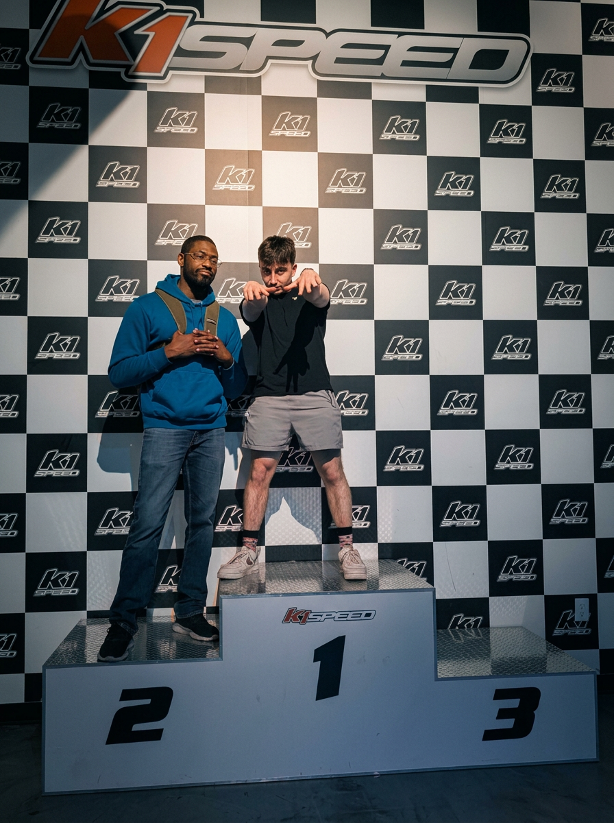 Two teammates on a podium at a go-kart track